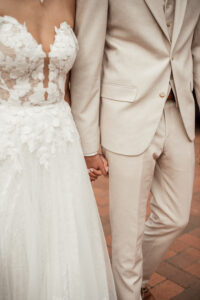 Braut und Bräutigam halten Händchen, keine Gesichter zu erkennen