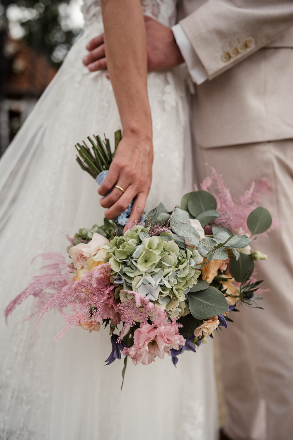 Brautstrauß im Vordergrund, Brautpaar im Hintergrund