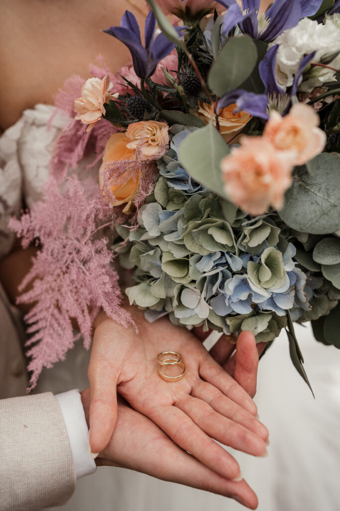 Traditionen -Brautstrauß mit Ringen auf der Handfläche der Braut